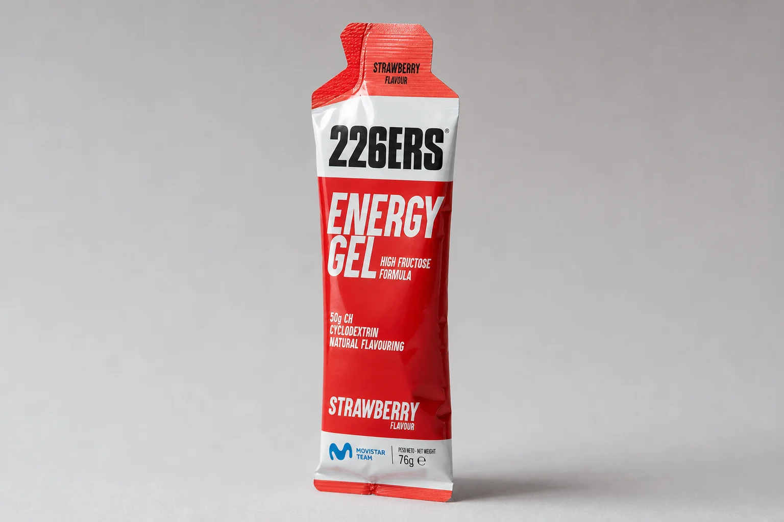 Thirteen energy gel packets arranged in a grid on concrete surface