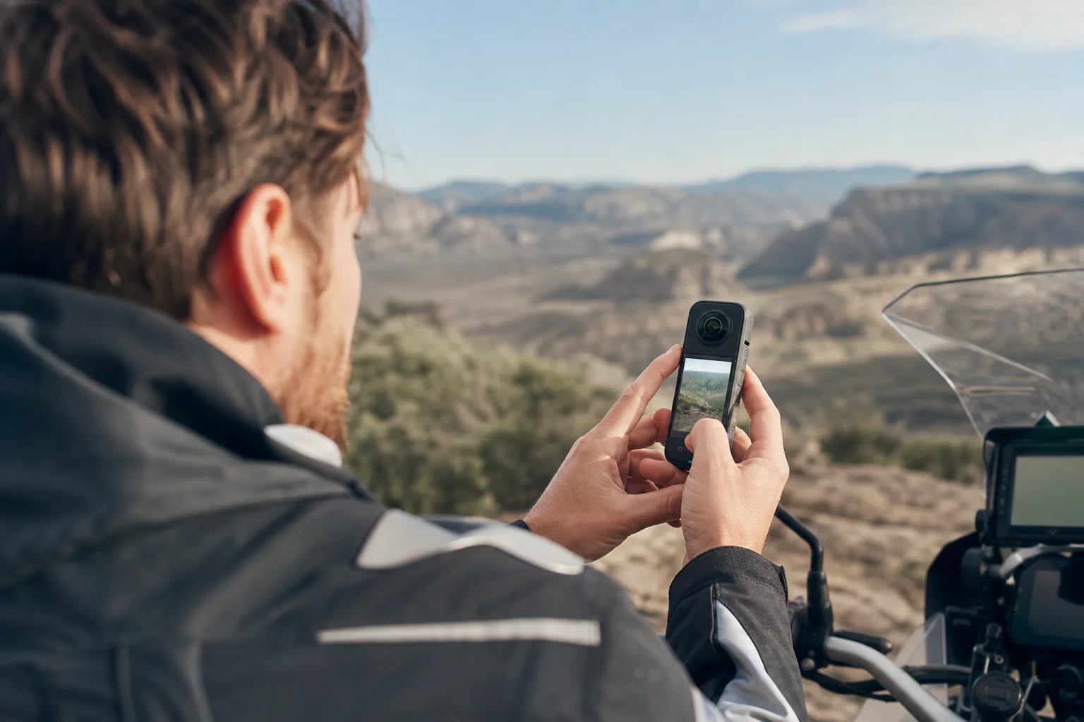 Motorcyclist adjusting 360 camera settings on bright LCD screen