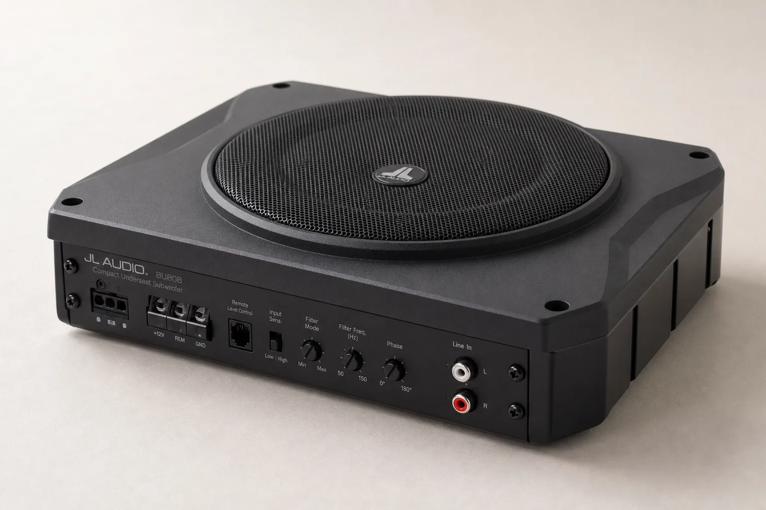 Six underseat subwoofers of varying sizes arranged on concrete surface