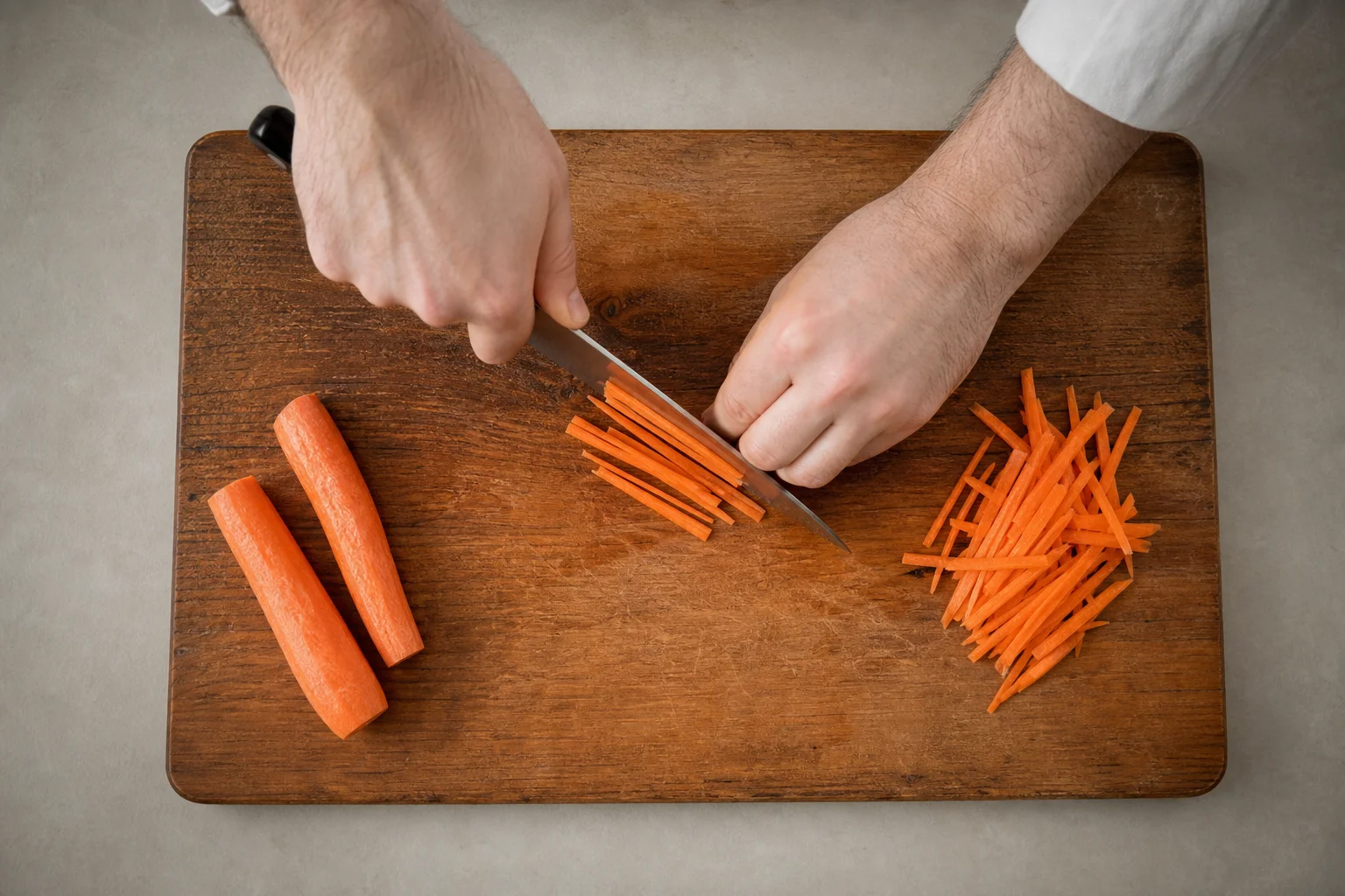 Chef's hands demonstrating a rocking motion with a knife on a cutting board
