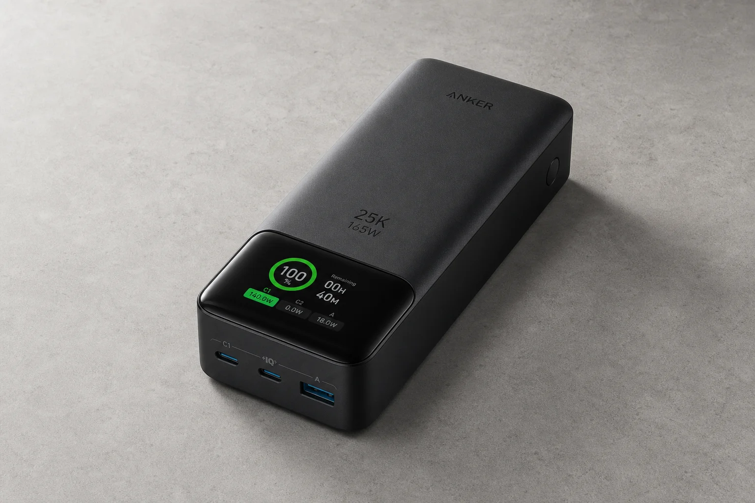 Anker 25K Laptop Power Bank on matte concrete with digital display visible