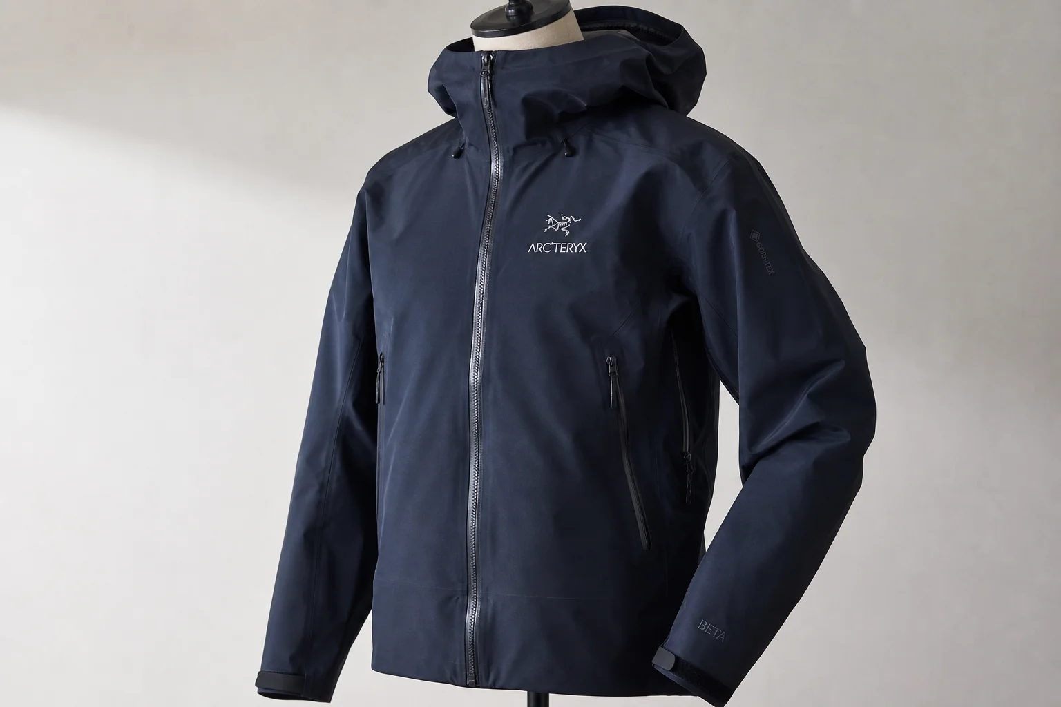 Five waterproof jackets in different colors and styles arranged on concrete