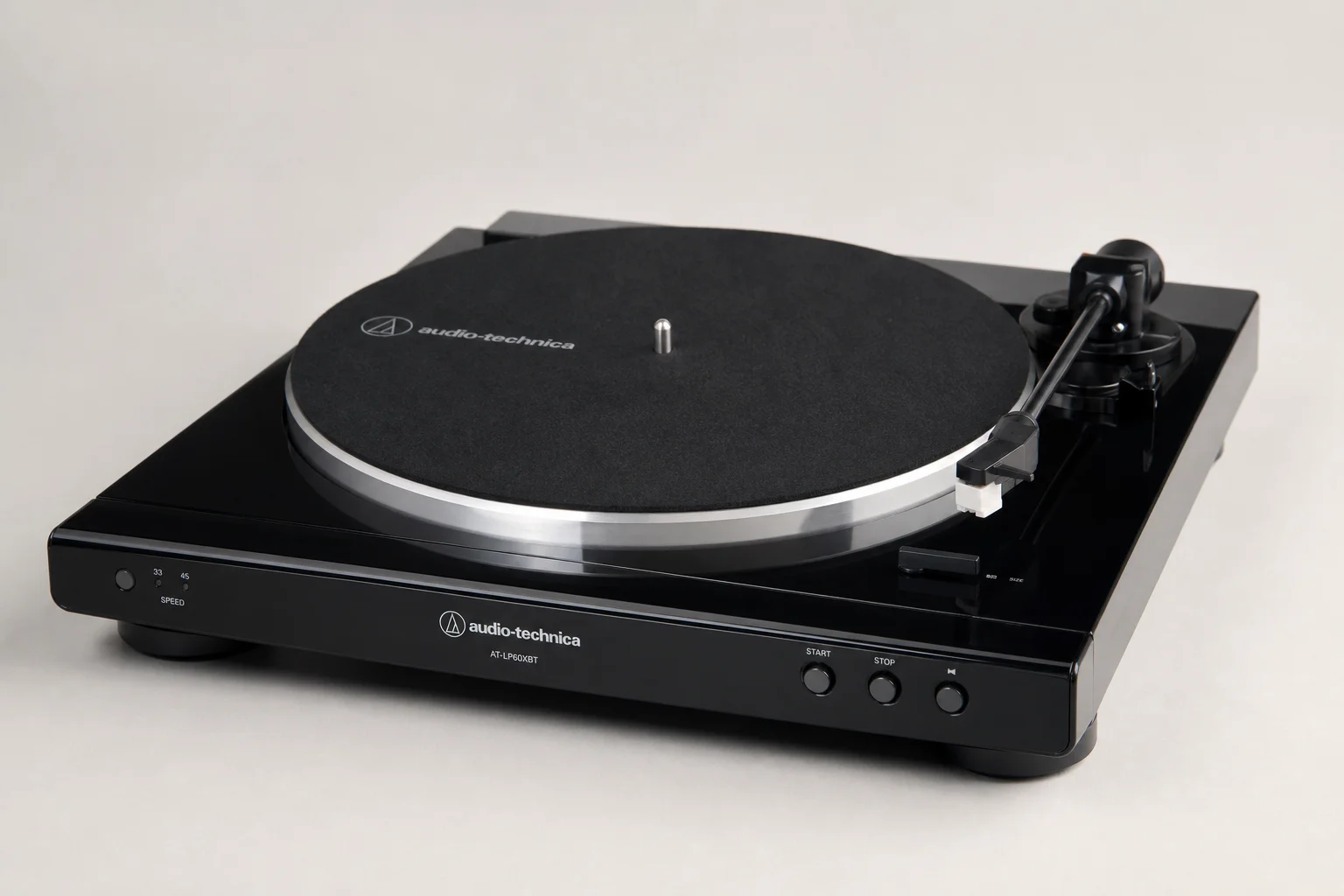 Five vinyl turntables arranged by price tier on concrete surface