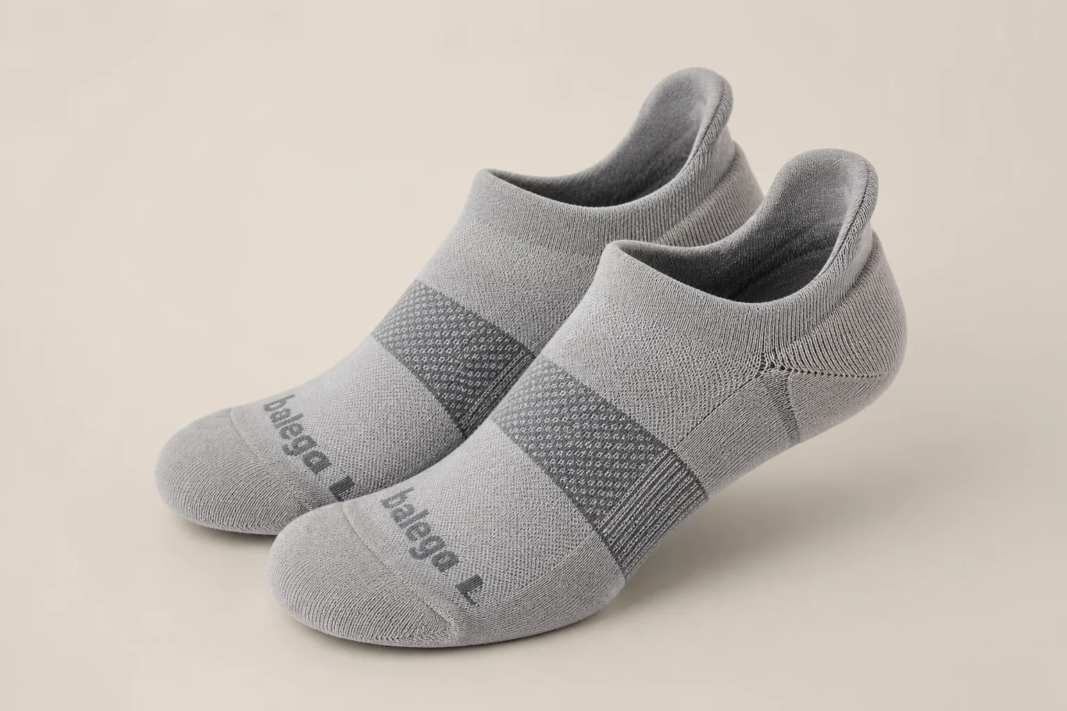 Collection of various running socks in different colors and styles on neutral backdrop
