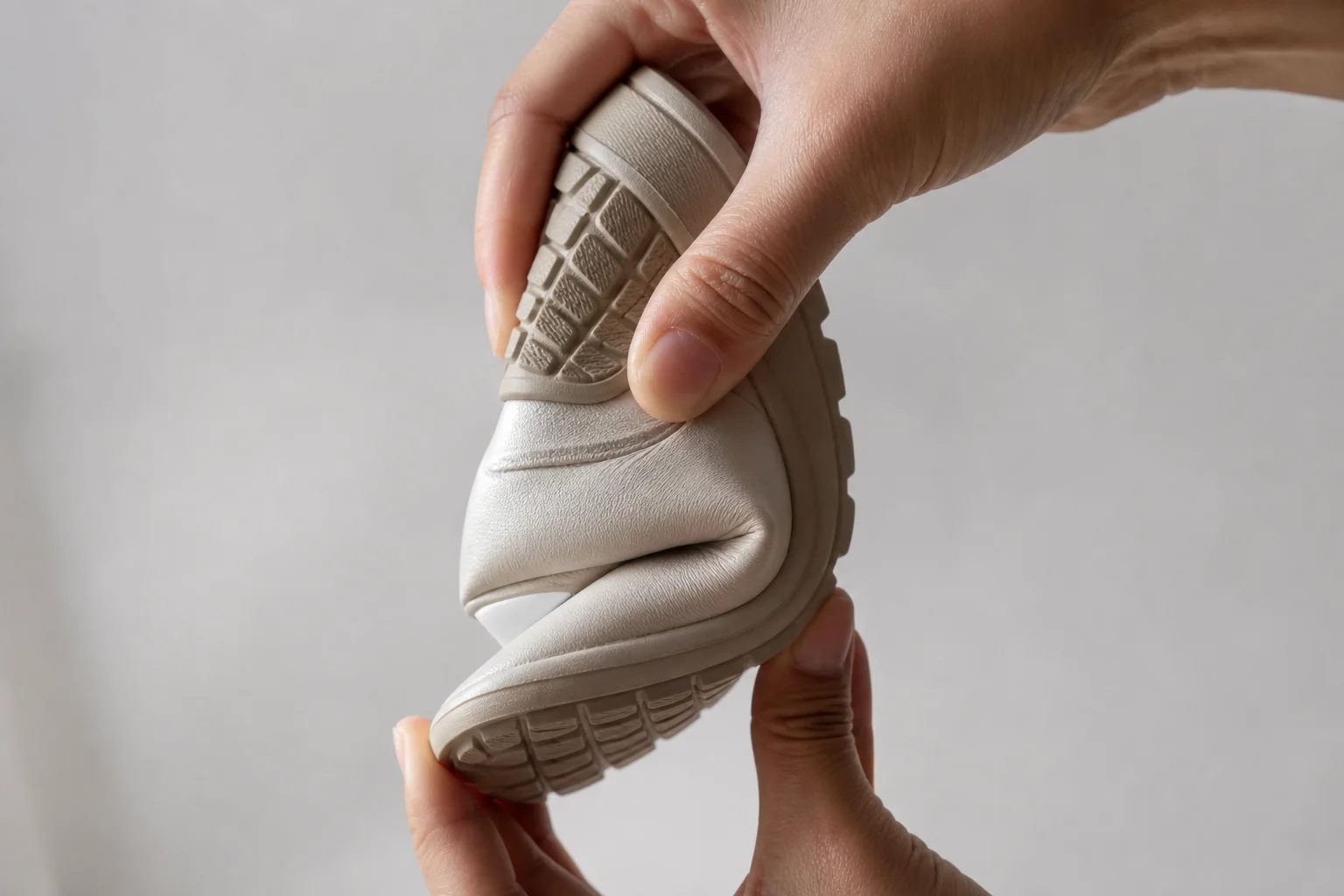 Shoe sole being flexed by hand to show flexibility and bend