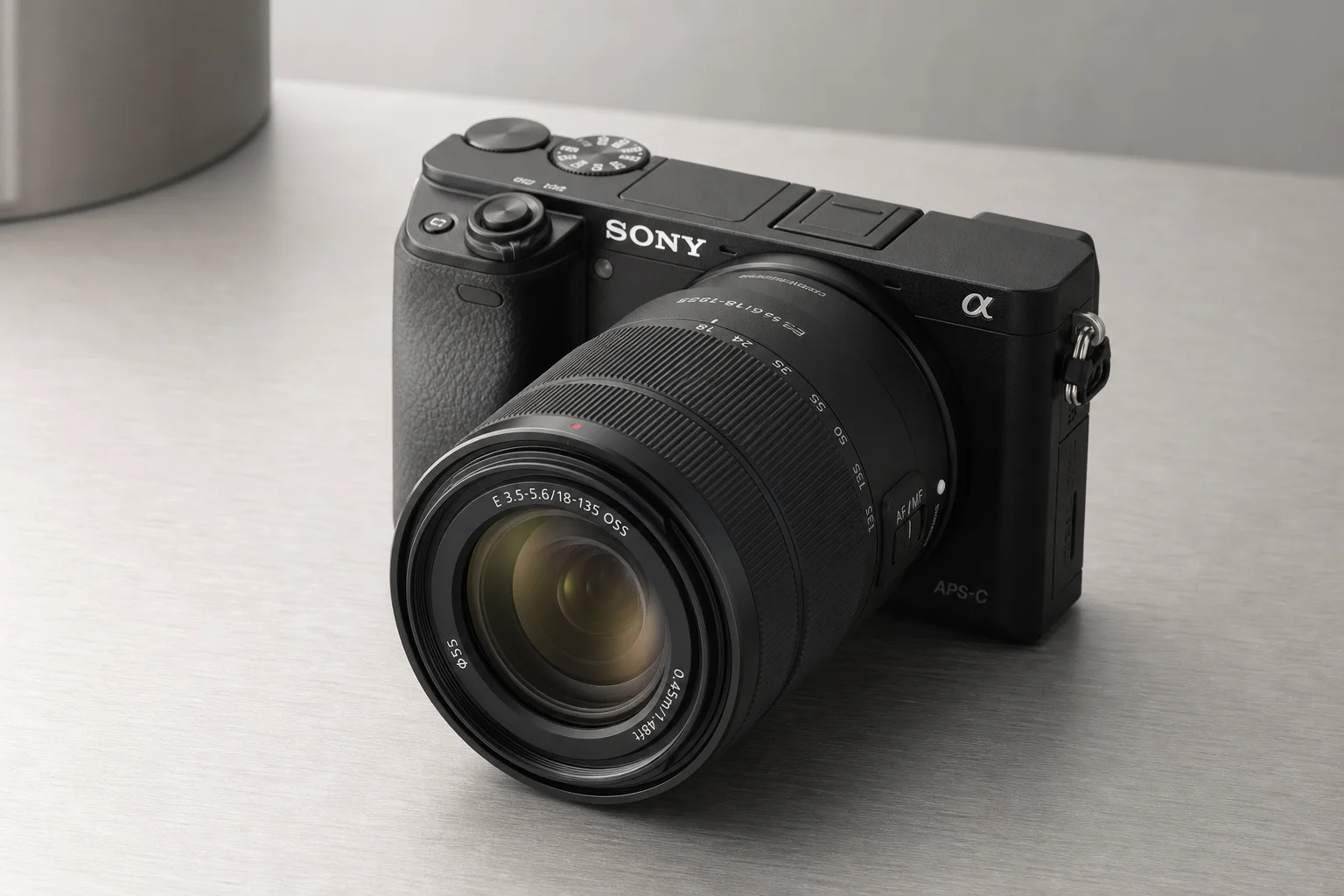 Sony A6400 mirrorless camera with attached zoom lens on brushed aluminium surface