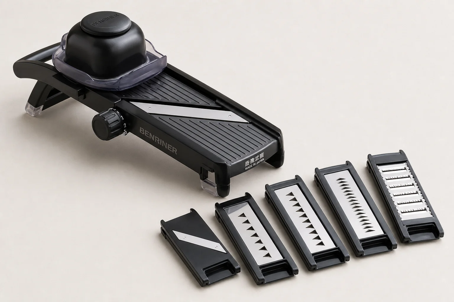Benriner Japanese mandoline with guard and interchangeable blade cartridges on neutral backdrop