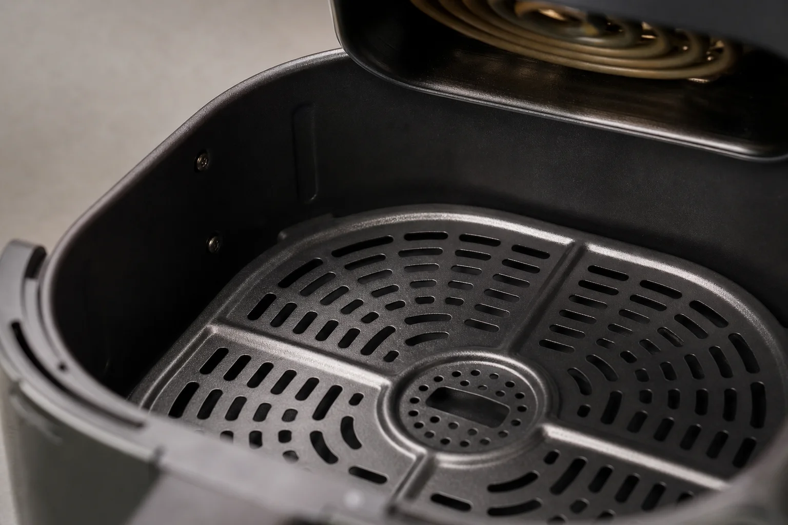 Close-up of air fryer basket interior showing perforated surface and heating element