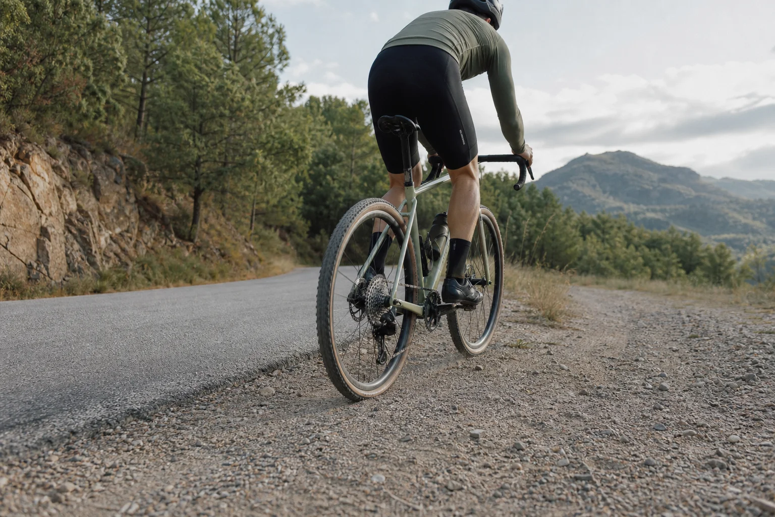 Cyclist navigating a mixed-terrain route with pavement and gravel sections