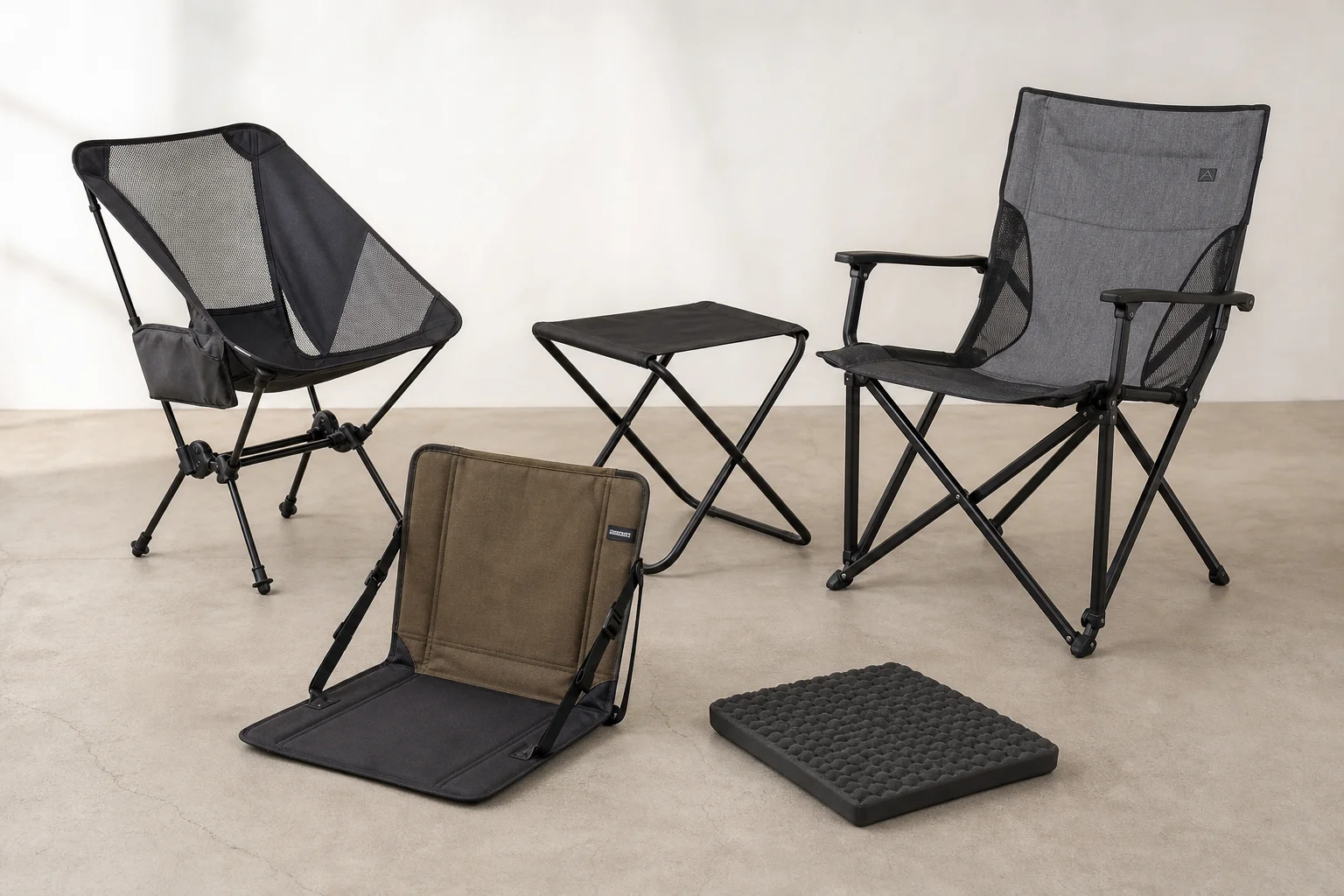 Five backpacking chairs arranged on concrete surface showing variety of styles and weights