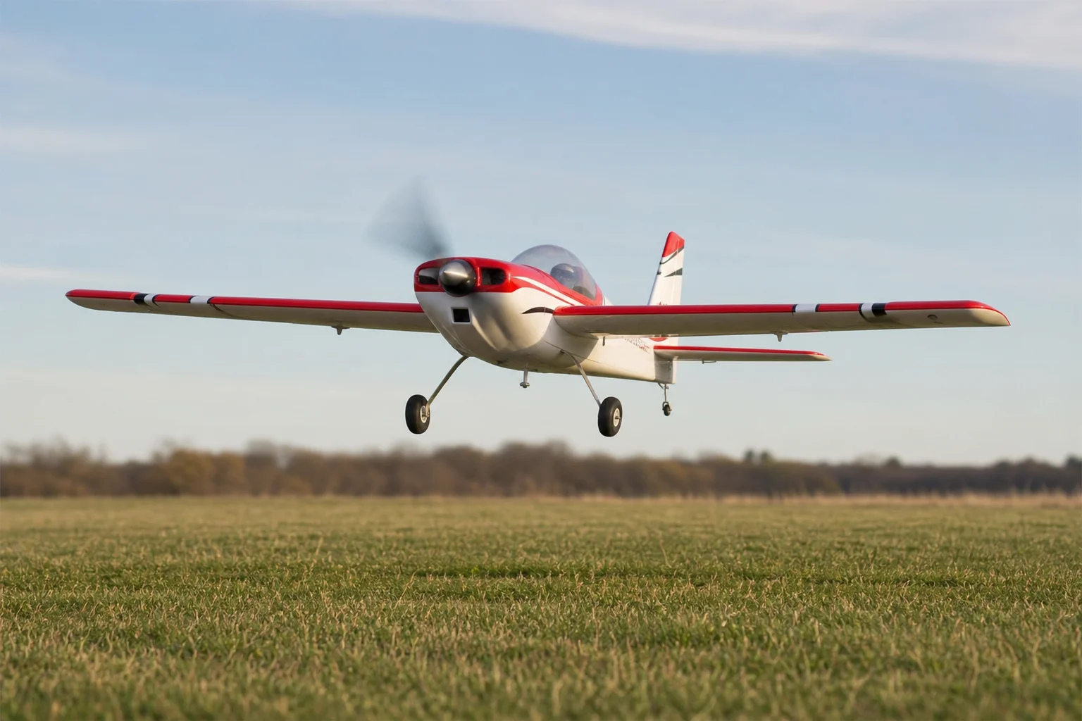 RC plane landing on grass field with propeller visible