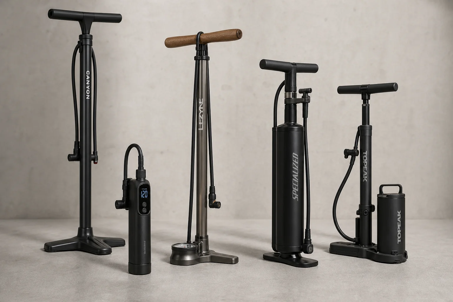 Five bike pumps displayed on concrete surface in staggered arrangement