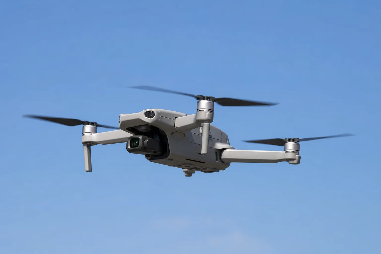 Foldable drone with extended arms against blue sky