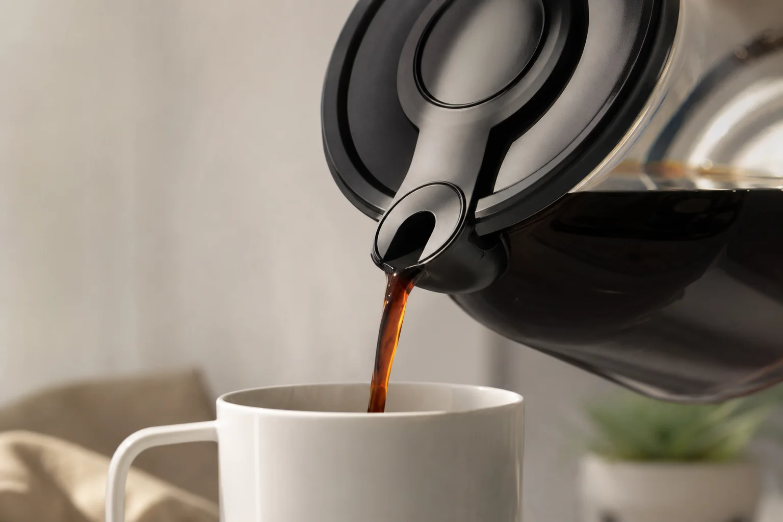 Nahaufnahme der tropffreien Bunn Kanne beim Eingießen von Kaffee in eine weiße Tasse