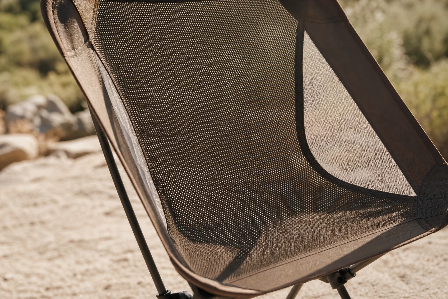 Silla de camping de malla bajo la luz del sol mostrando la construcción de tejido transpirable