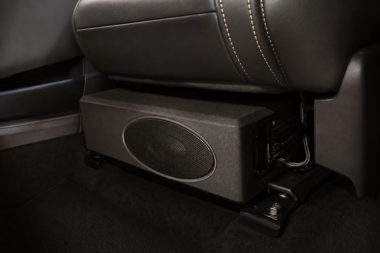 Compact subwoofer mounted under a car front seat