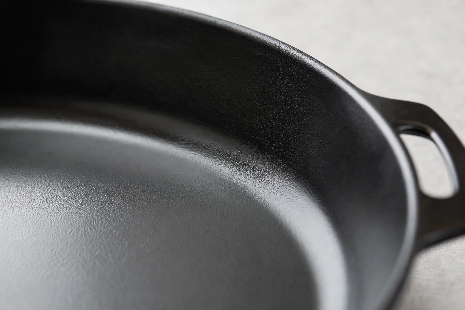 Close-up of smooth cast iron surface texture with light reflections