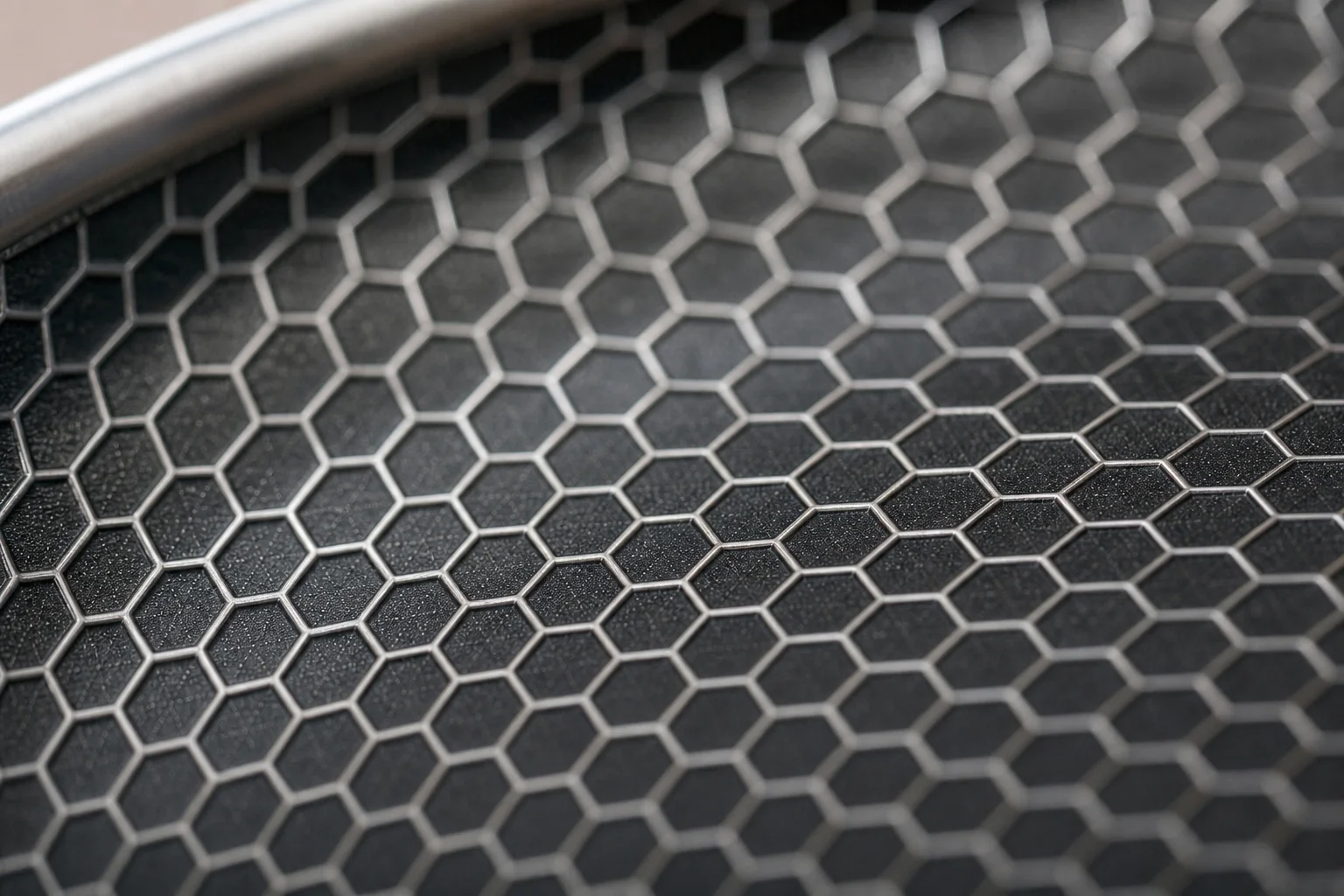 Close-up of HexClad hybrid surface showing raised hexagonal steel pattern