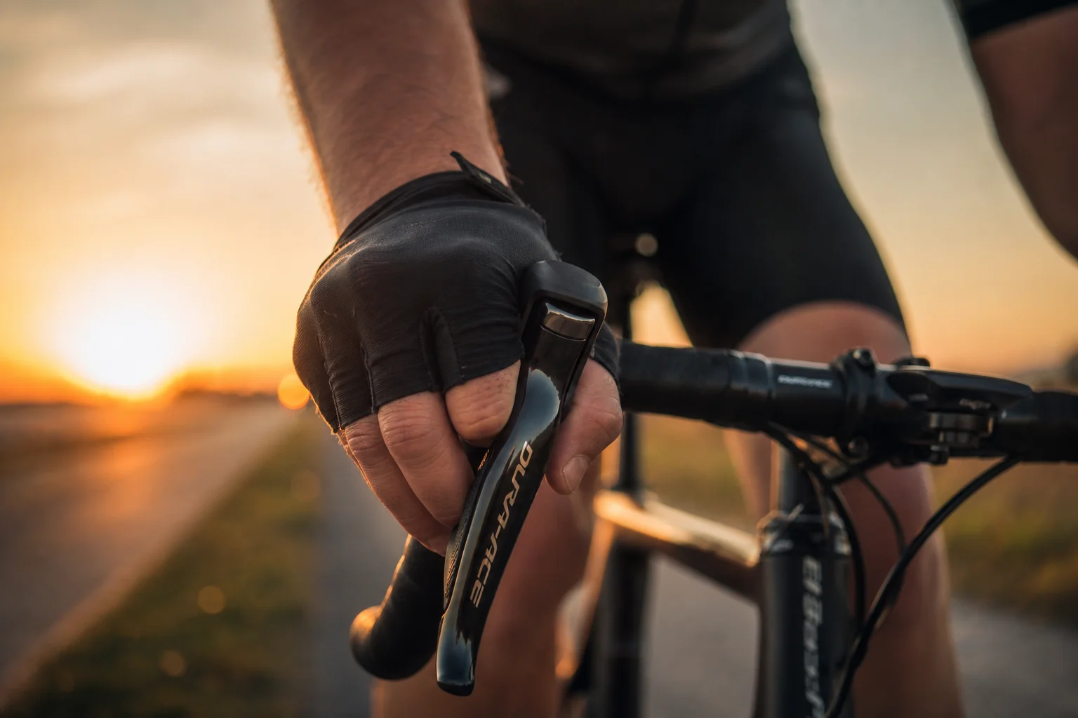 Cycling accessories laid flat on concrete ground, including carbon wheelsets, bike lights, and cycling shorts
