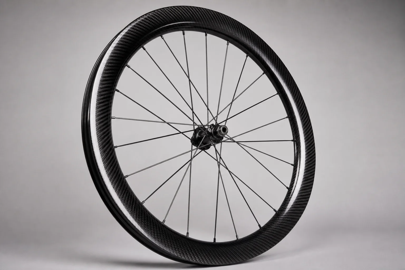 Cycling accessories flat-lay including carbon wheels, handlebar light, and bib shorts on concrete