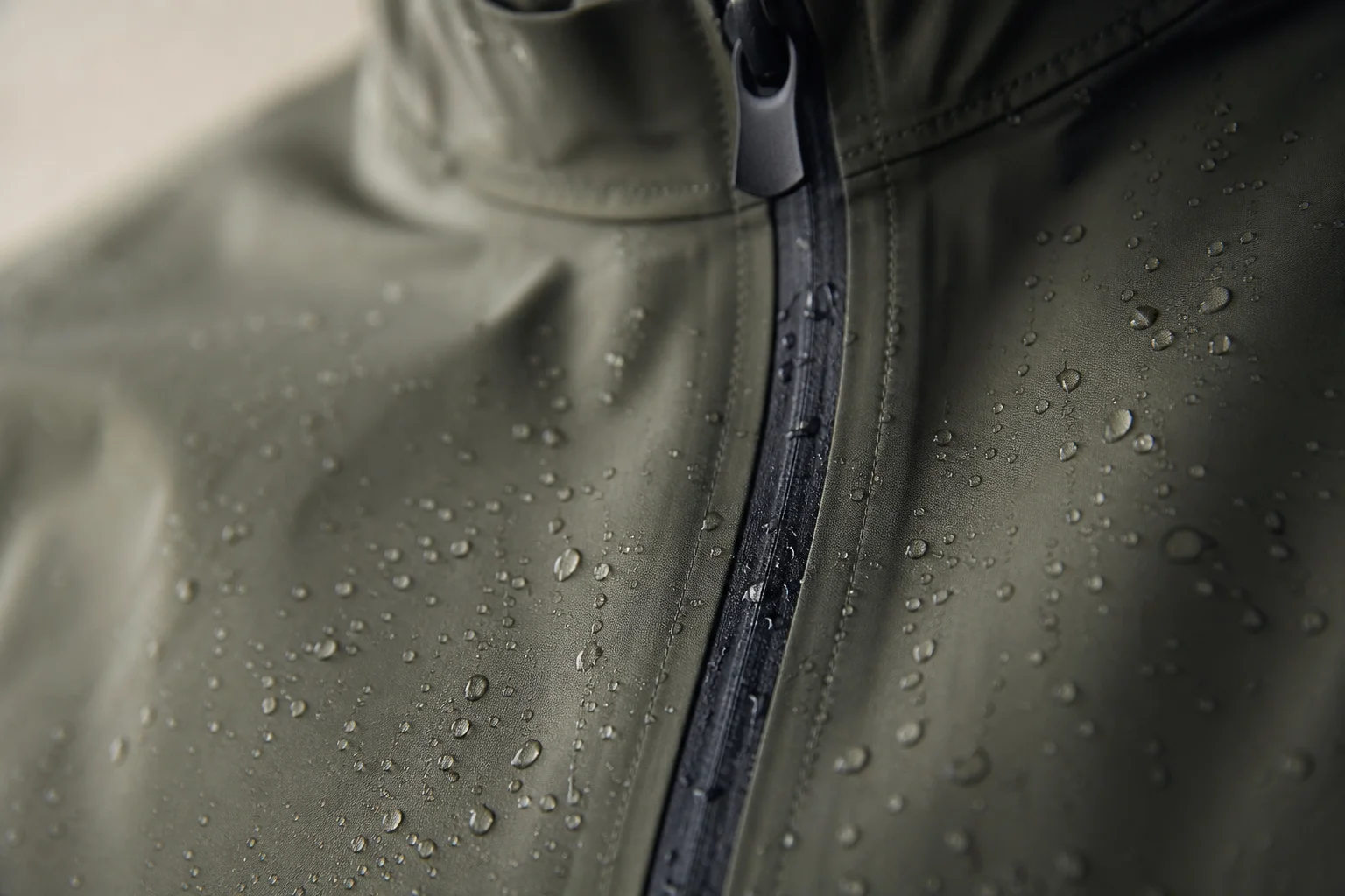 Close-up of jacket seams and zipper with water droplets beading