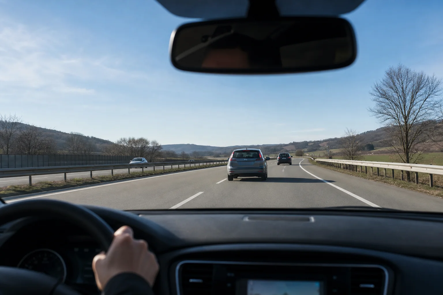 Dashboard view through car windshield showing road and traffic