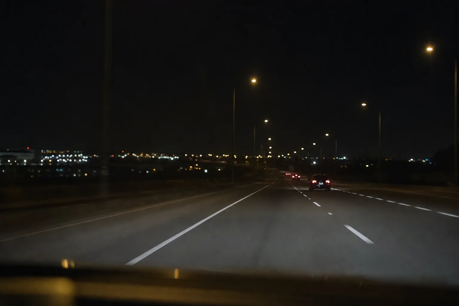 Night driving scene with road markings and street lights
