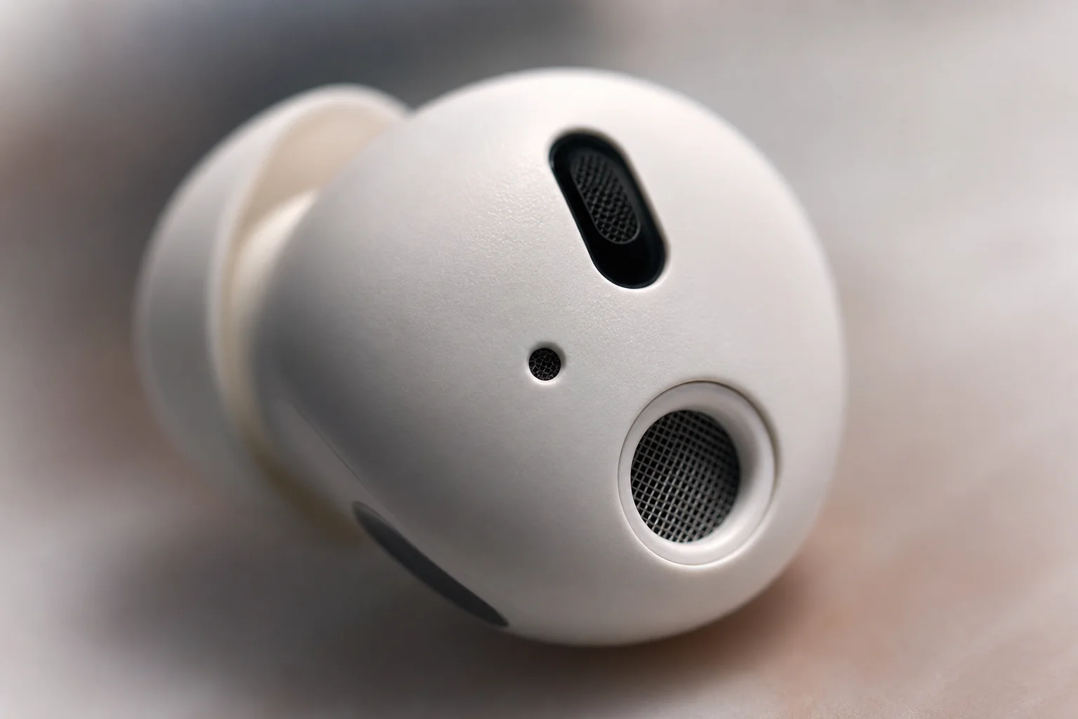 Close-up of earbud microphone mesh and noise-cancelling details