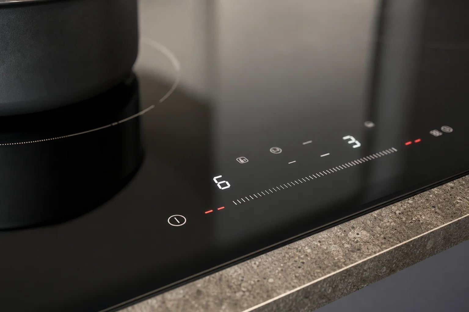 Close-up of digital cooktop controls with touch interface and display