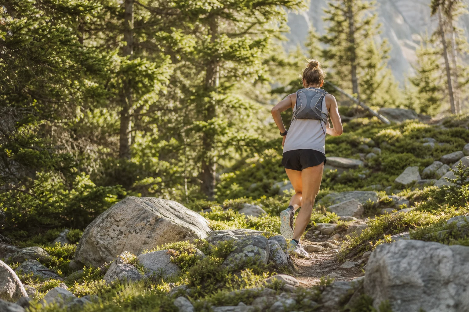 Runner in motion on a sunny trail with water bottle