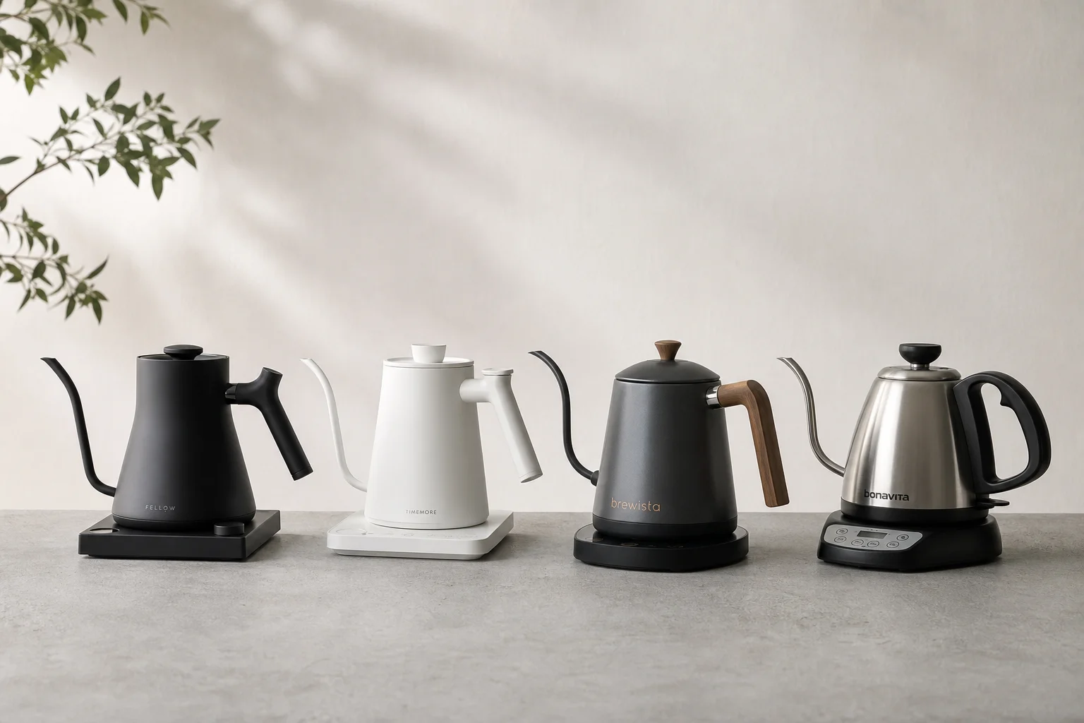 Four gooseneck kettles lined up on concrete surface showing design variations