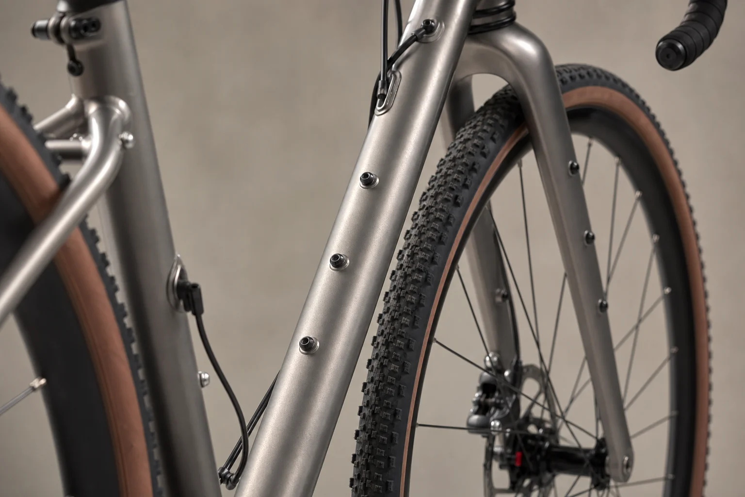 Close-up detail of a gravel bike frame showing multiple mounting points for racks and bags