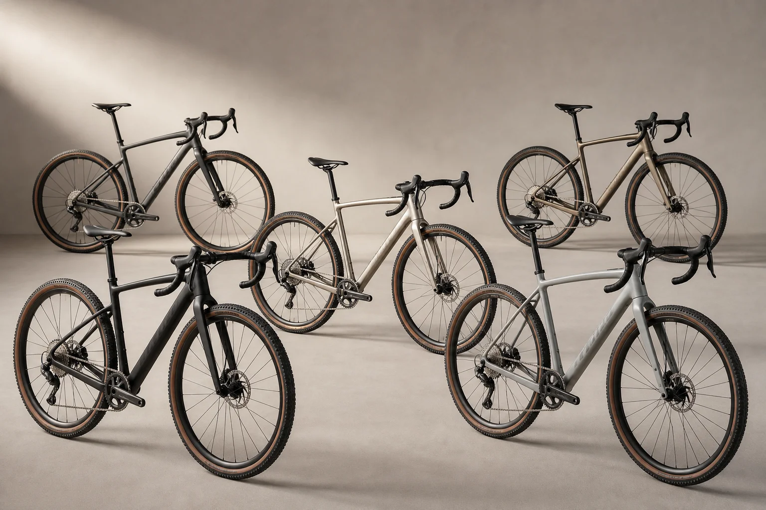 Five gravel bikes arranged in staggered composition showing different frame styles and geometries