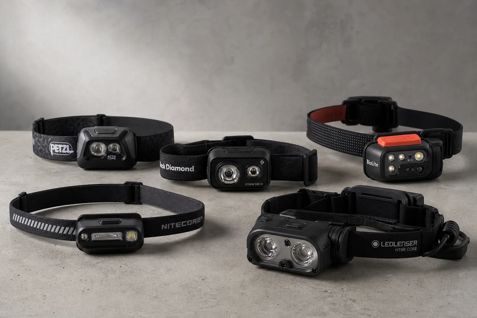 Five headlamps displayed on concrete surface showing range from compact to professional models