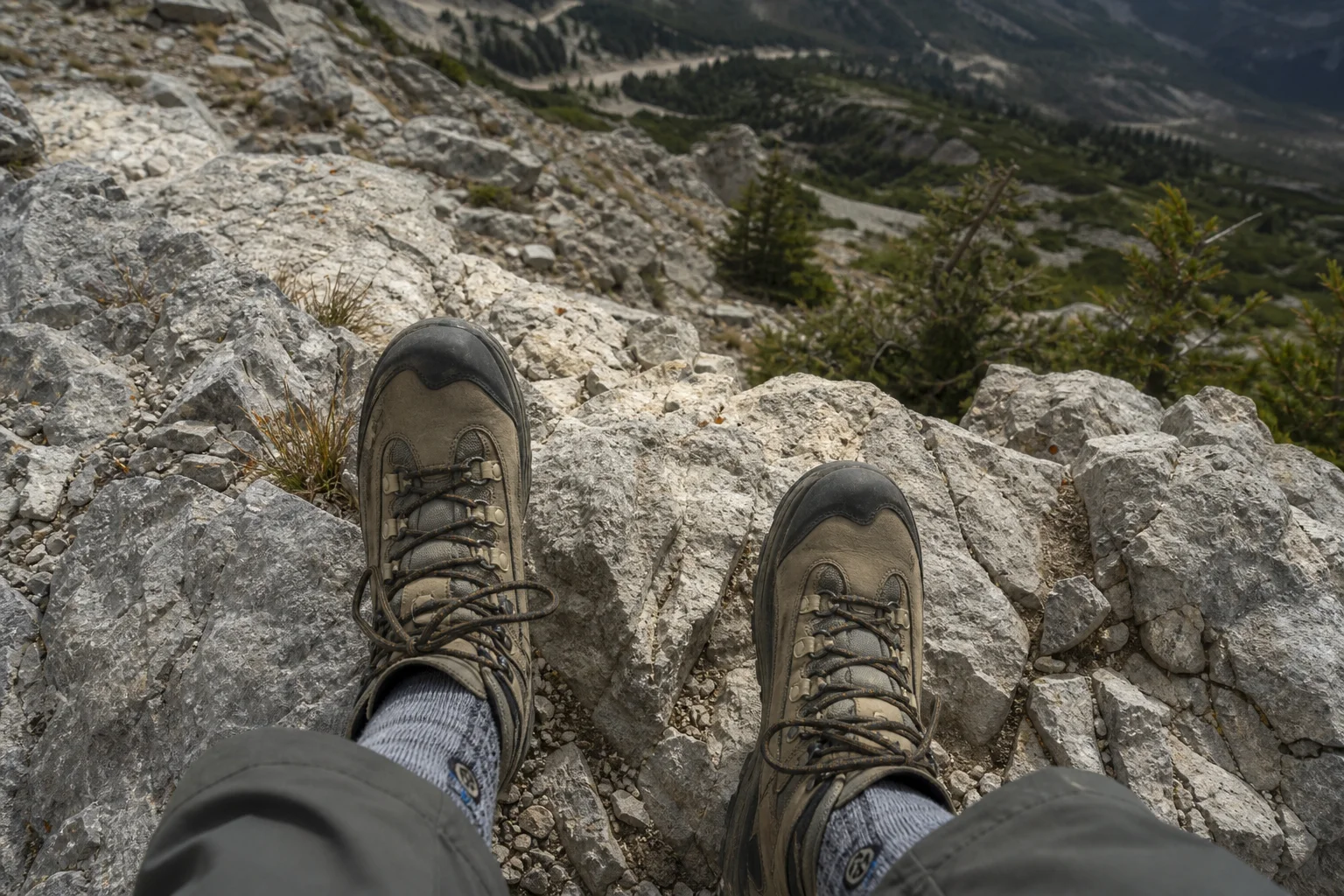 Hiker's feet on rocky mountain trail with mid-weight cushioned socks