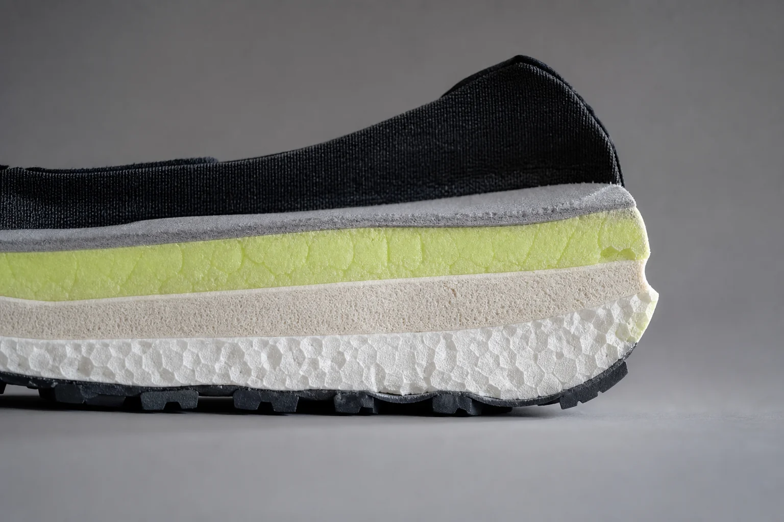 Close-up of trail shoe midsole showing foam cushioning layers and stack height