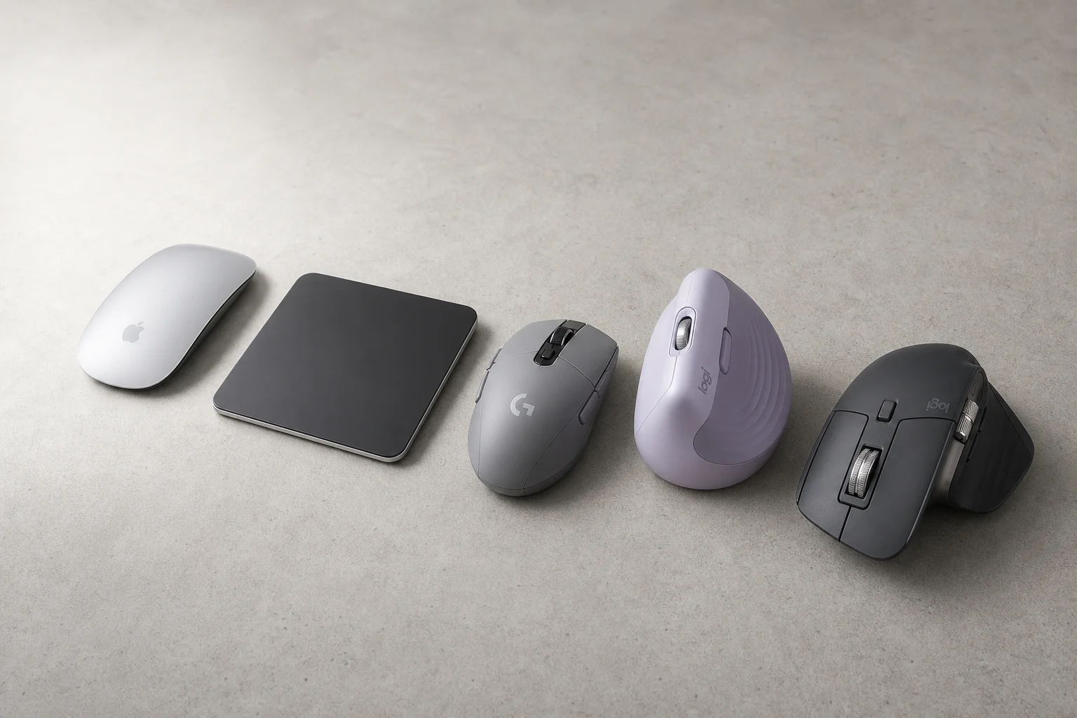 Five computer mice arranged on a concrete surface: Apple Magic Mouse, Magic Trackpad, Logitech G305, Lift, and MX Master 3