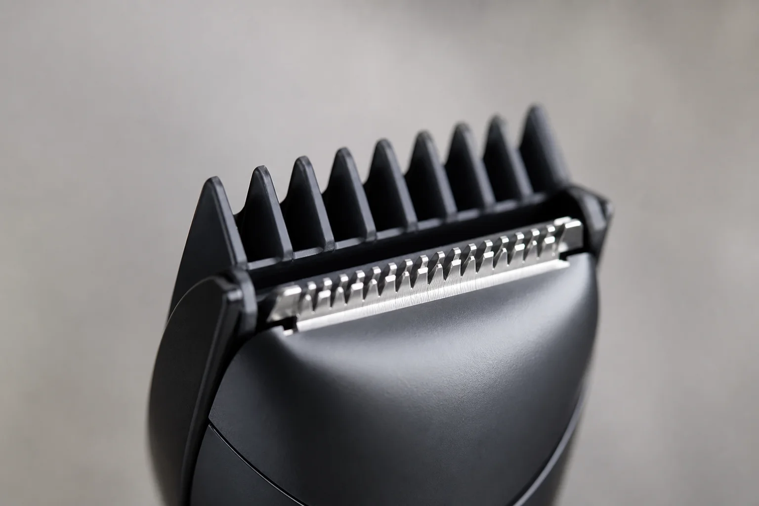 Close-up of a trimmer blade with protective guard in soft lighting