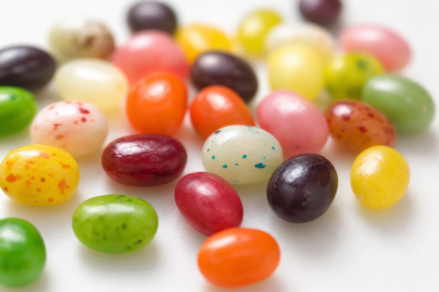 Close-up of colorful sport beans scattered on a white surface