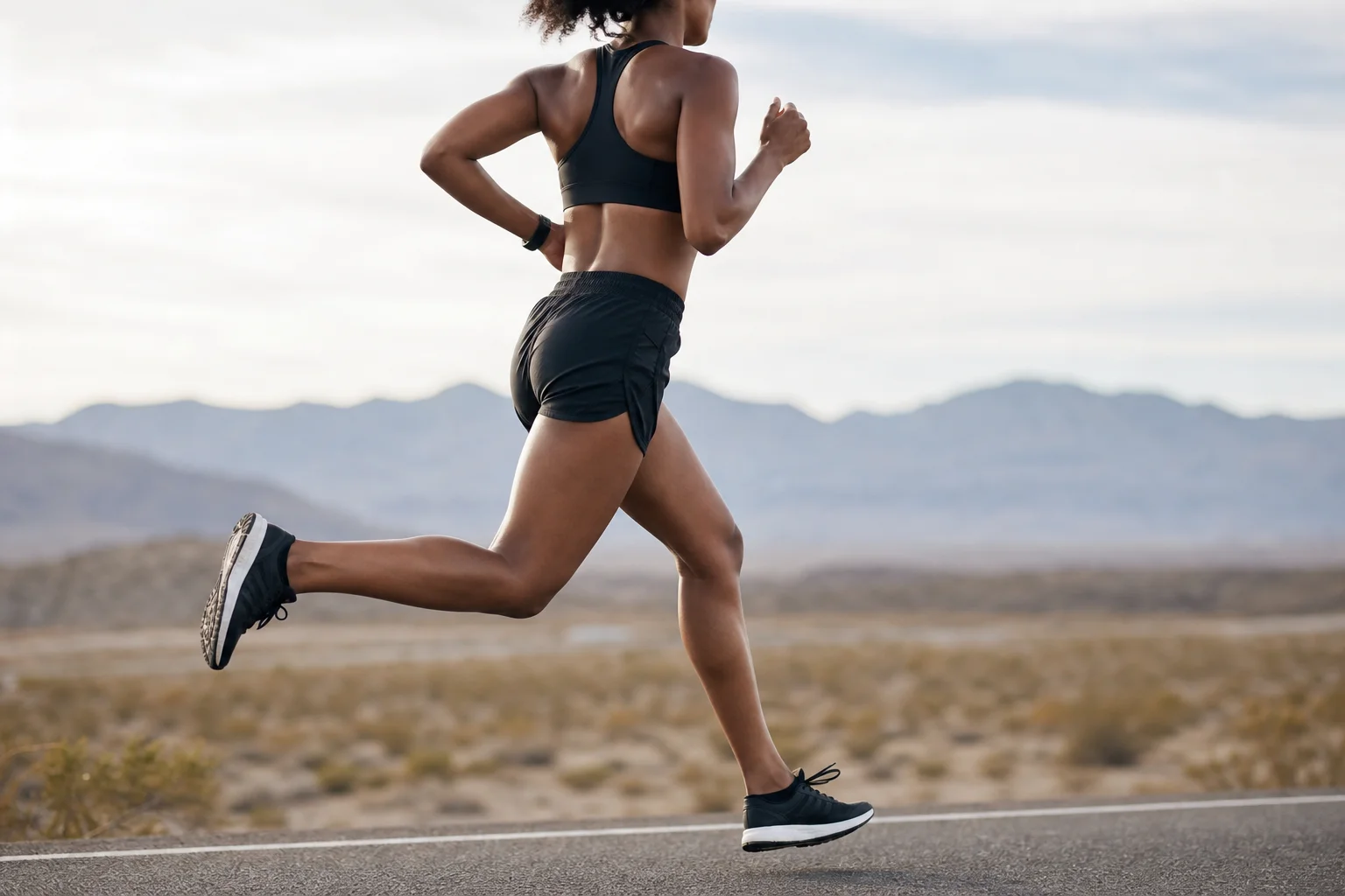 Runner crossing finish line with energy and determination in daylight