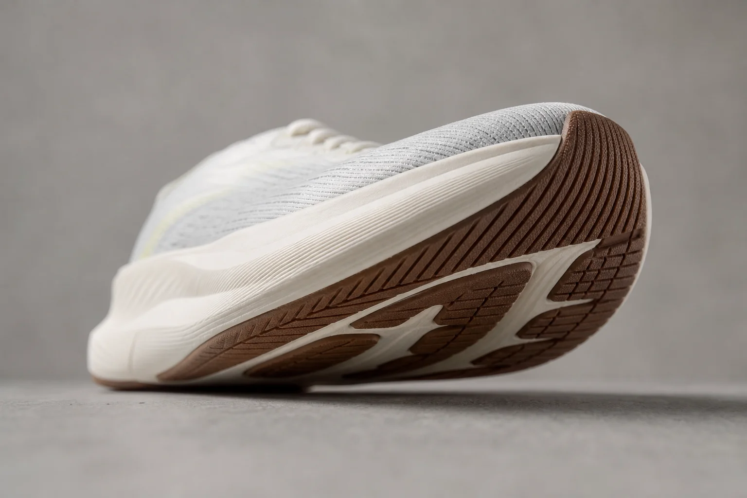 Shoe sole detail showing rocker profile and forefoot design on neutral surface