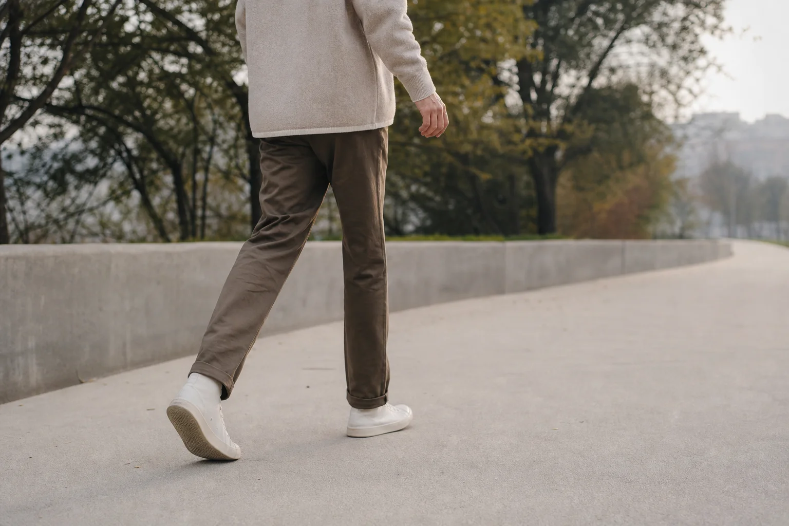 Person walking on a paved path in natural daylight