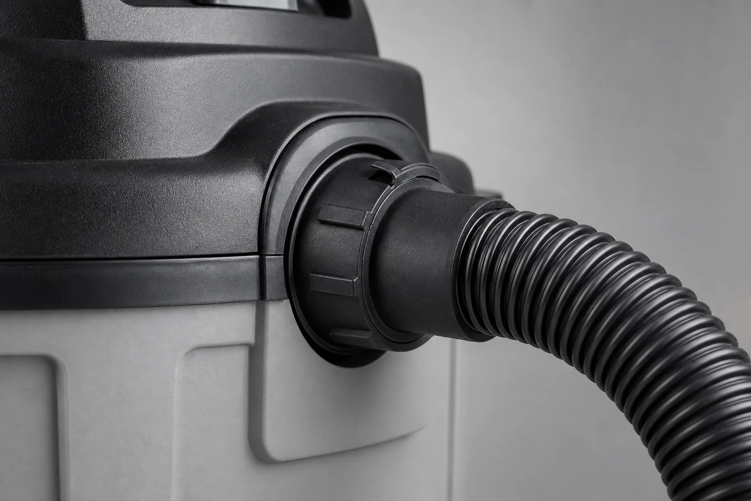 Close-up of a shop vacuum hose connection showing locking mechanism and flexibility