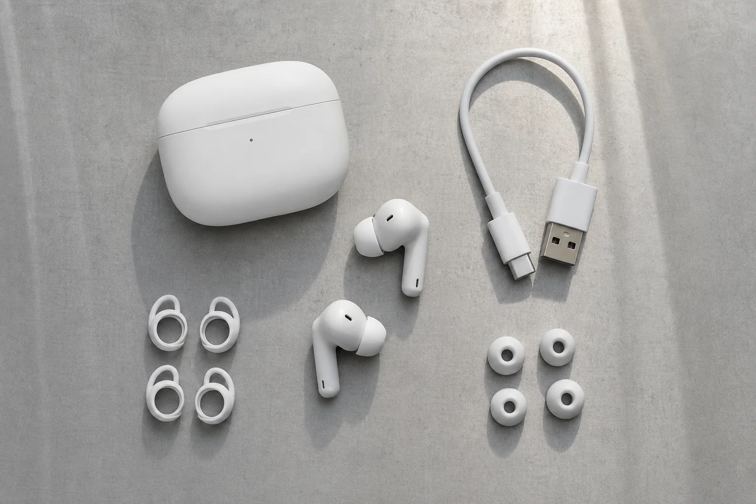Earbud charging case and accessories arranged on minimalist surface