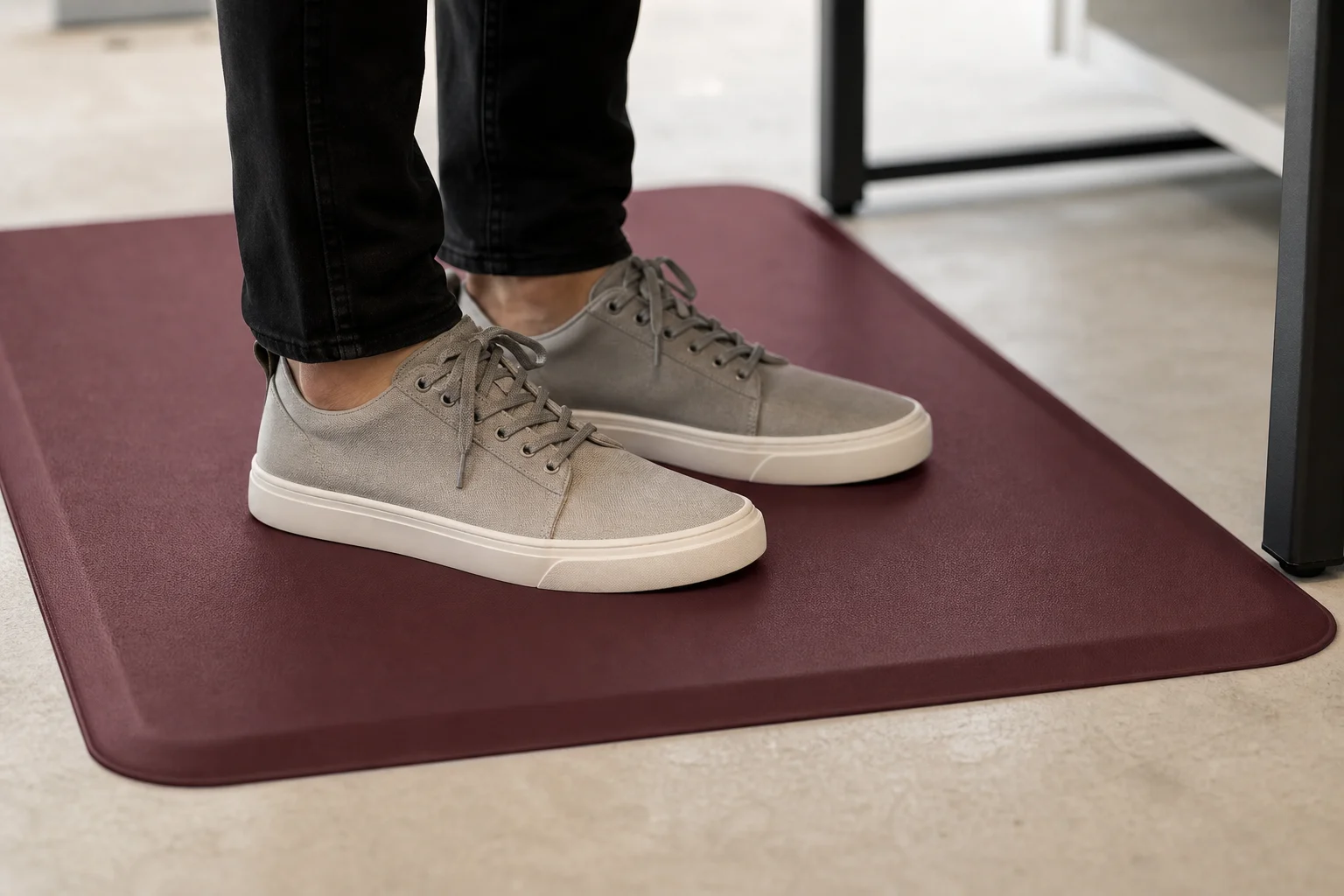 Close-up of feet on burgundy anti-fatigue mat in office
