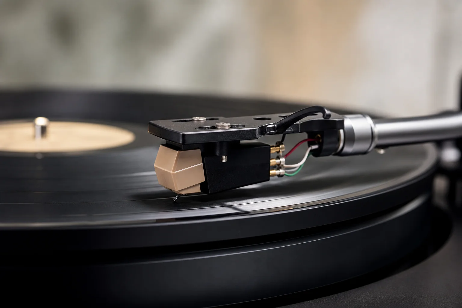 Turntable tonearm and cartridge in detail with vinyl record background