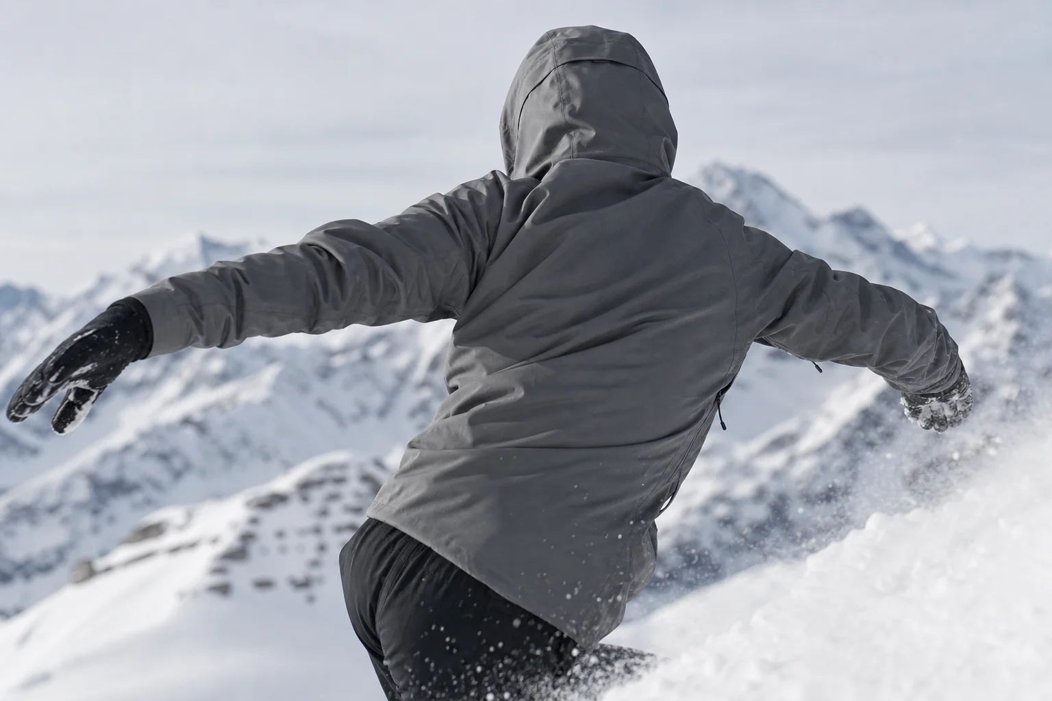 Athlete in stretchy jacket moving dynamically on snowy mountain slope
