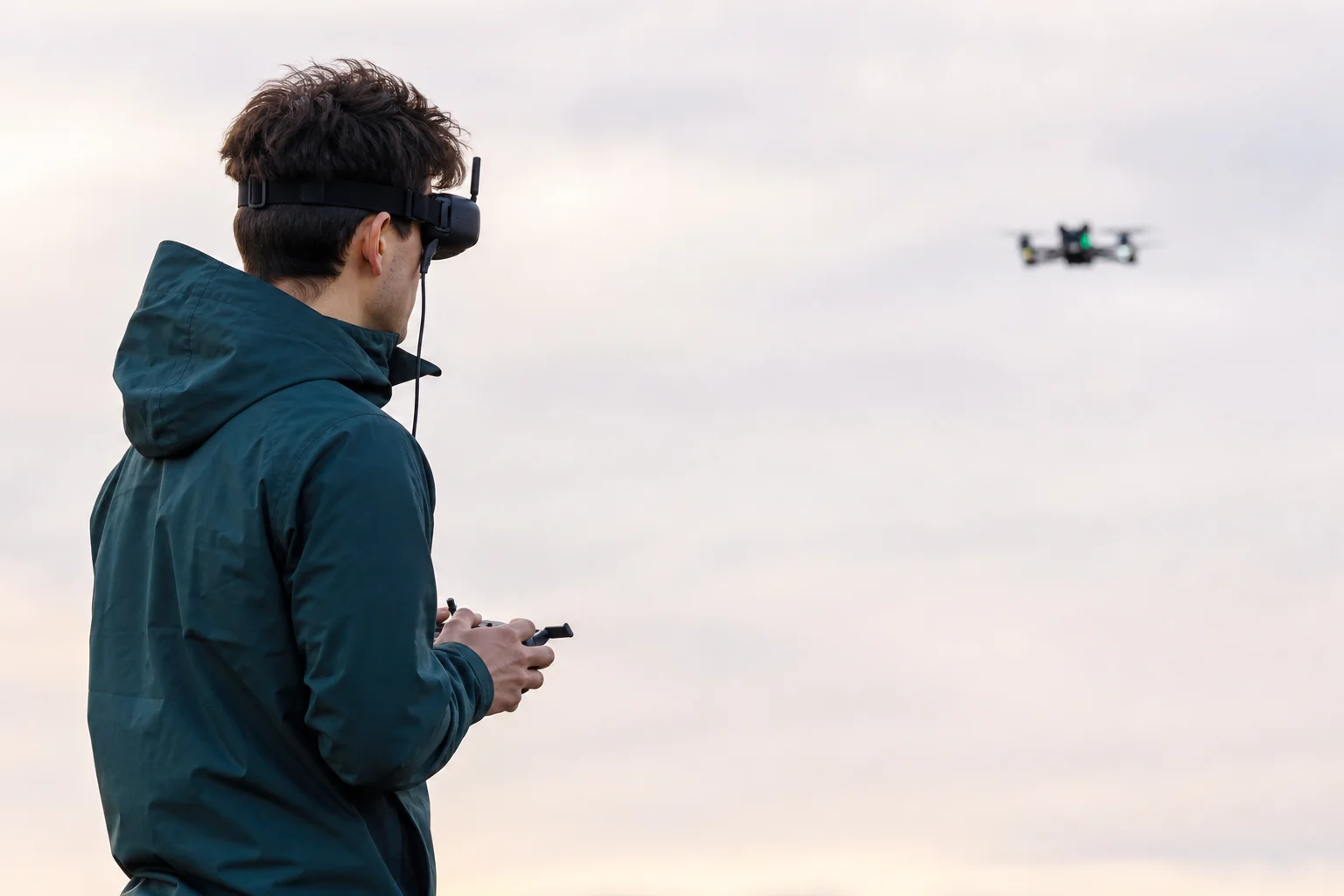 Pilota FPV principiante che indossa occhiali e pilota un tiny whoop