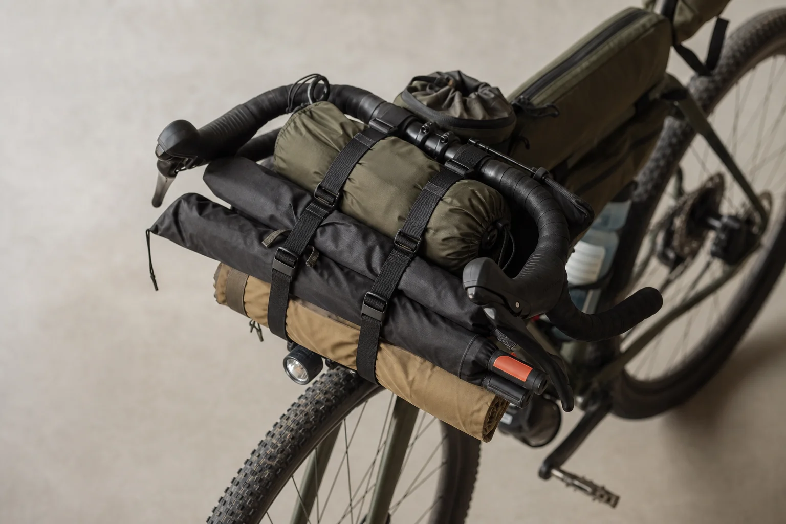 Handlebar cradle with frame bags and camp chairs on a bikepacking bike