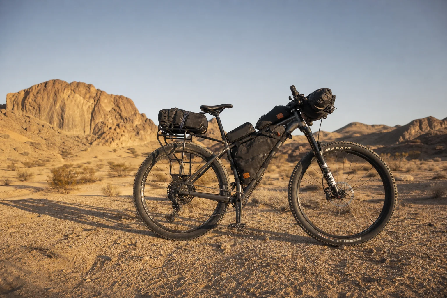 Hardtail mountain bike loaded with bikepacking bags on desert terrain